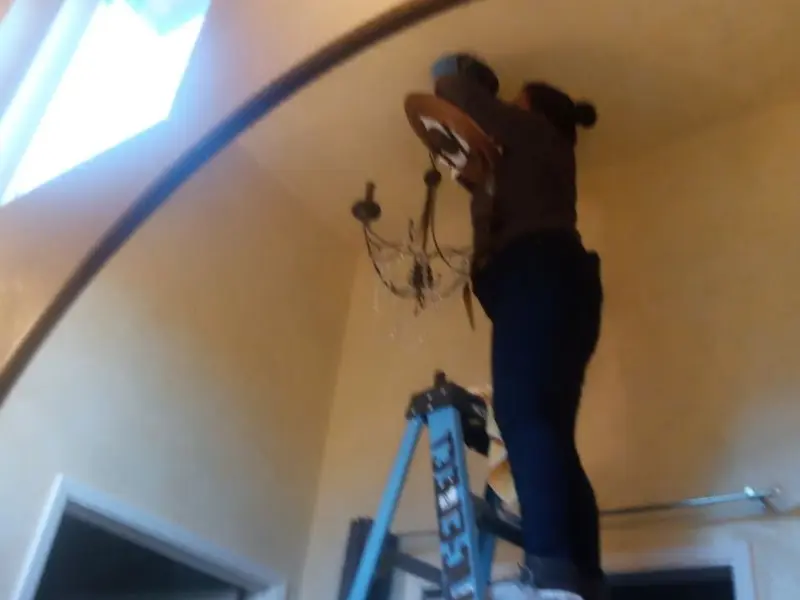 Electrician installing a chandelier in a Newberry residence